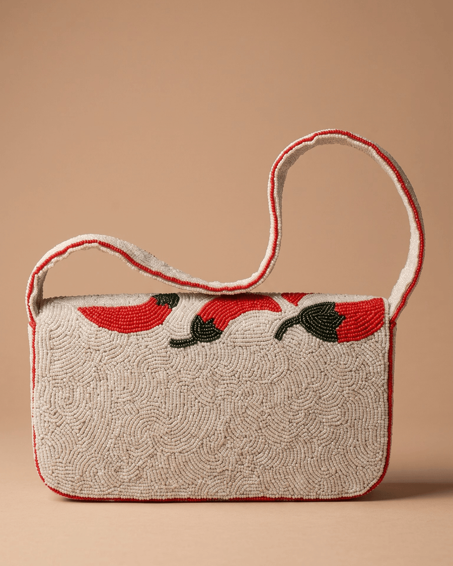Back of The Cayenne showing densely hand-beaded cream beadwork with red chilies trailing along the top edge.