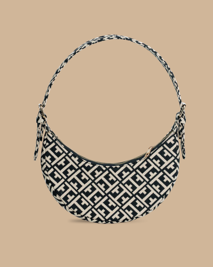 The Greco shoulder bag — front view of the navy-and-ivory jacquard crescent bag