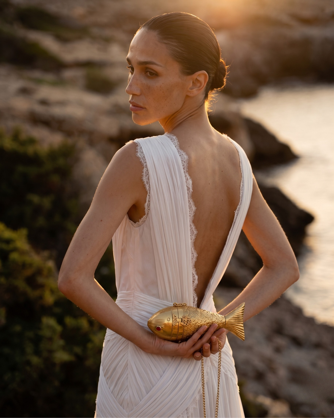 The Siren Fish minaudière worn by a model as an evening accessory