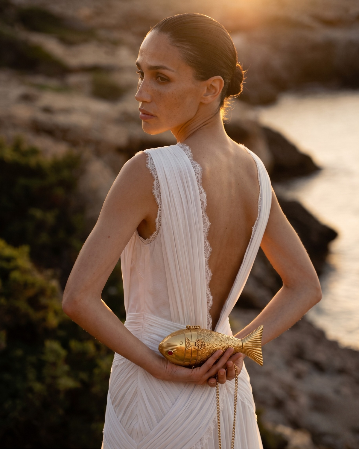 The Siren Fish minaudière worn by a model as an evening accessory