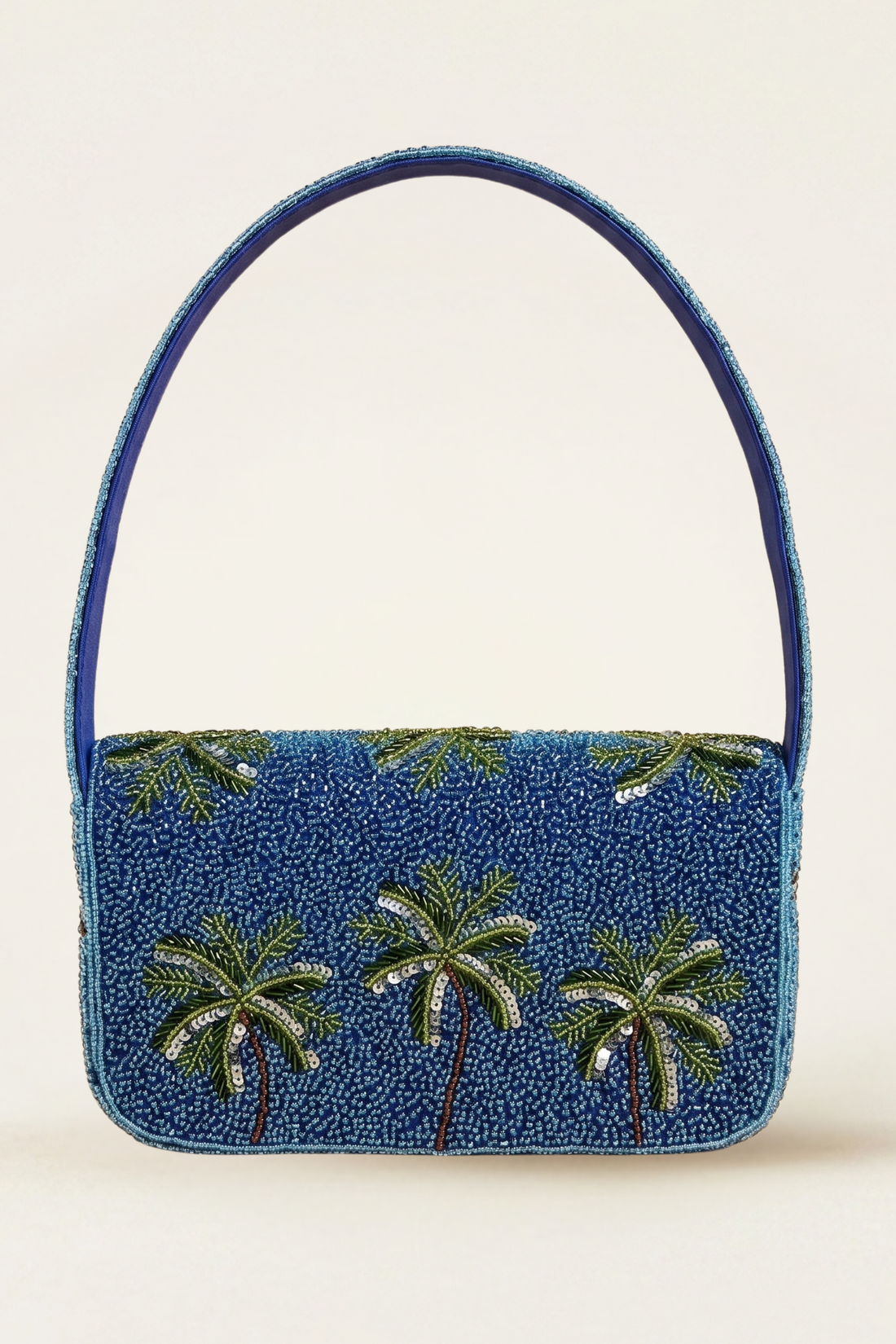 A blue beaded shoulder bag with an embroidered palm tree pattern and a matching blue beaded strap, shown against a plain light beige background.