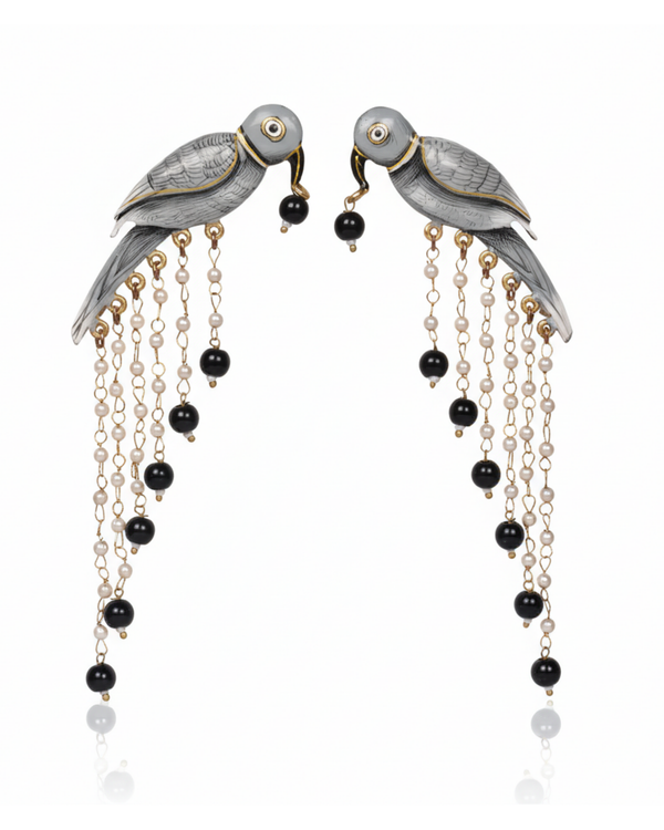 Graphite Parrot Chandelier Earrings carried by a model, styled for evening
