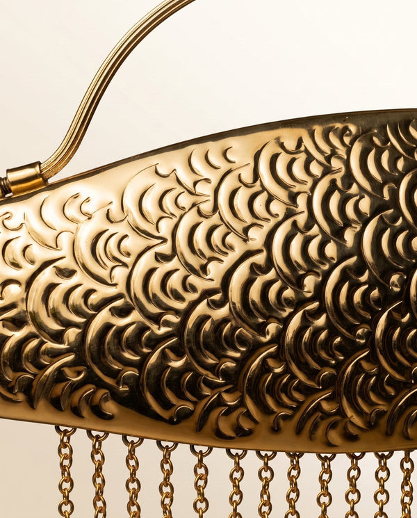 Raised brass scales of The Monsoon Fish clutch, with the chain fringe hanging below