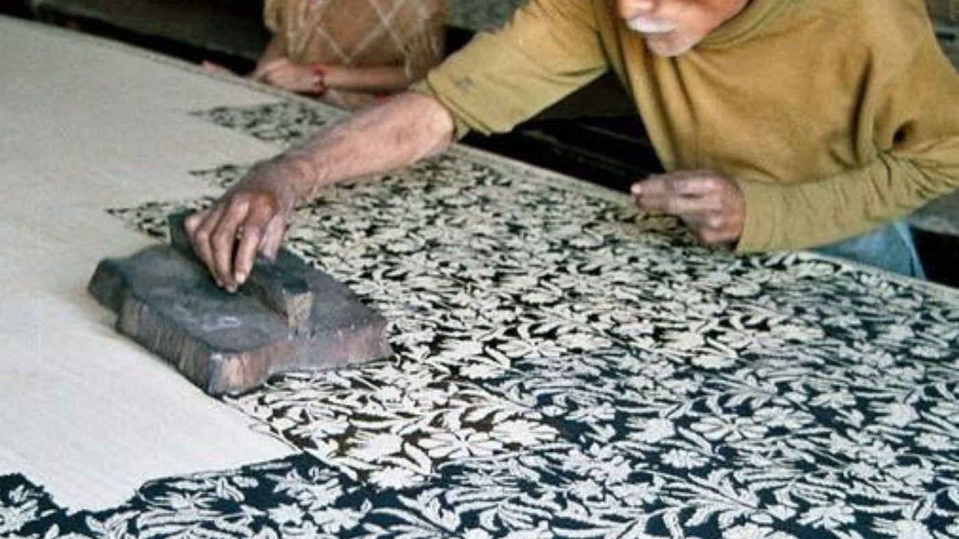 Hand block printing a floral pattern onto cotton in Rajasthan