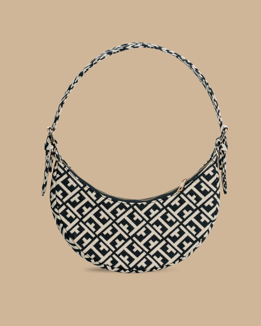 The Greco shoulder bag — front view of the navy-and-ivory jacquard crescent bag