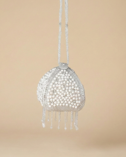 The Luna Pearl Prism, a dome-shaped silver potli bag encrusted with pearls and crystals with a beaded tassel fringe.