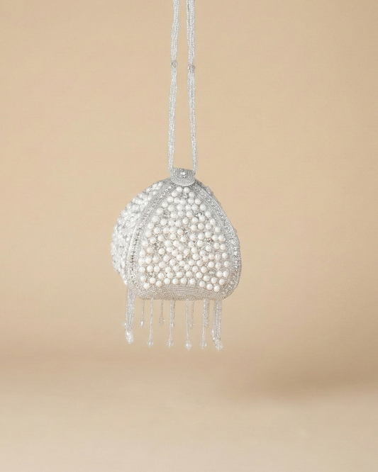 Front of The Luna Pearl Prism showing its pearl-and-crystal beadwork and dangling beaded fringe on a drawstring cord.