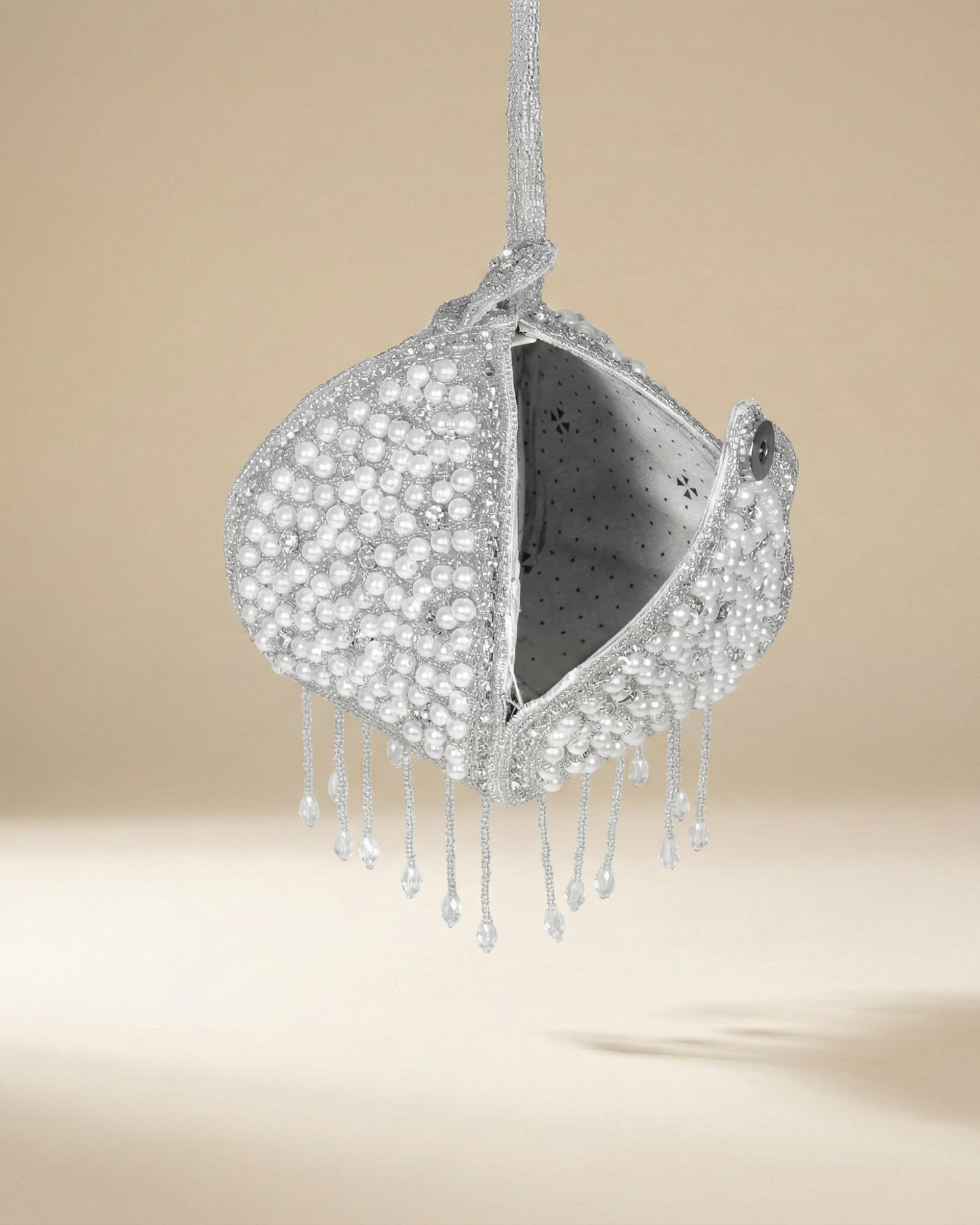 The Luna Pearl Prism opened to reveal its grey lining, framed by pearl beadwork and crystal-drop fringe.