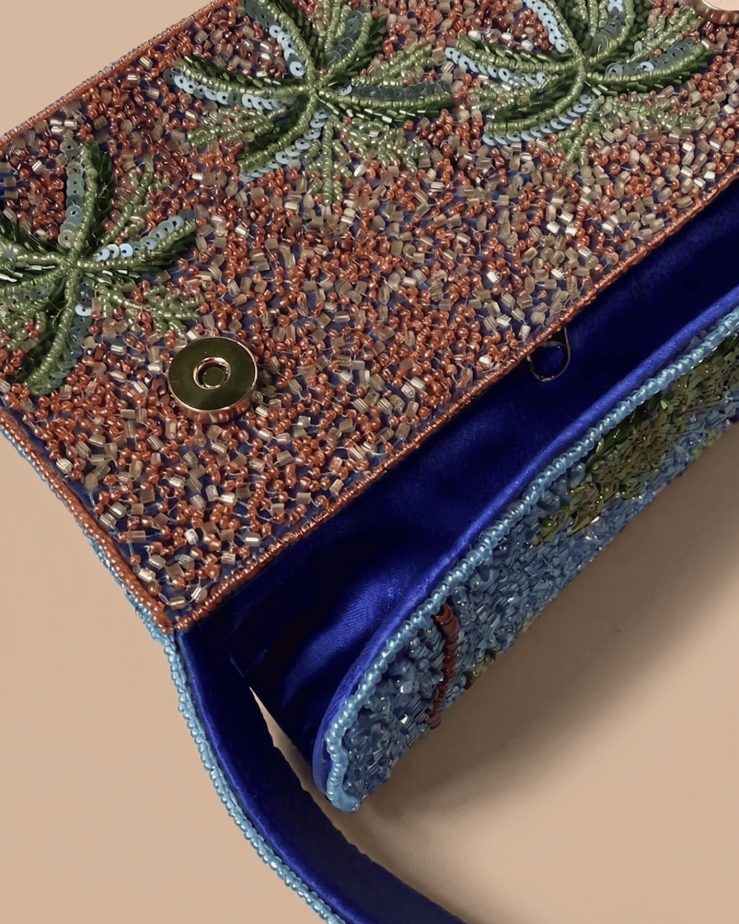 The Palma — interior view of the beaded palm-tree bag showing the magnetic snap closure and cobalt velvet lining, handcrafted detail.