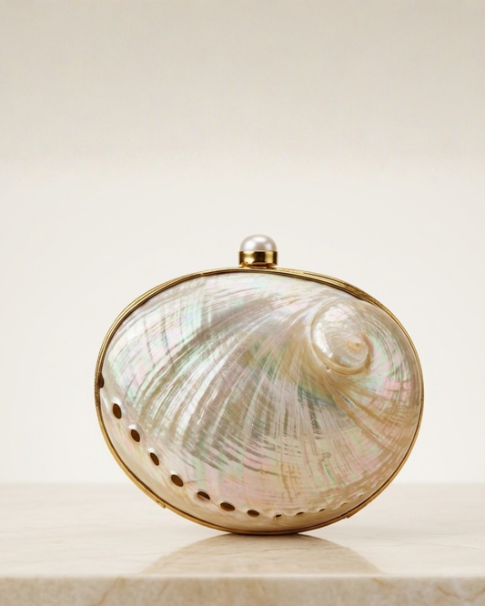 Front of The Eclat: an oval abalone-shell clutch with a gold rim, pearl clasp and perforated lower edge.