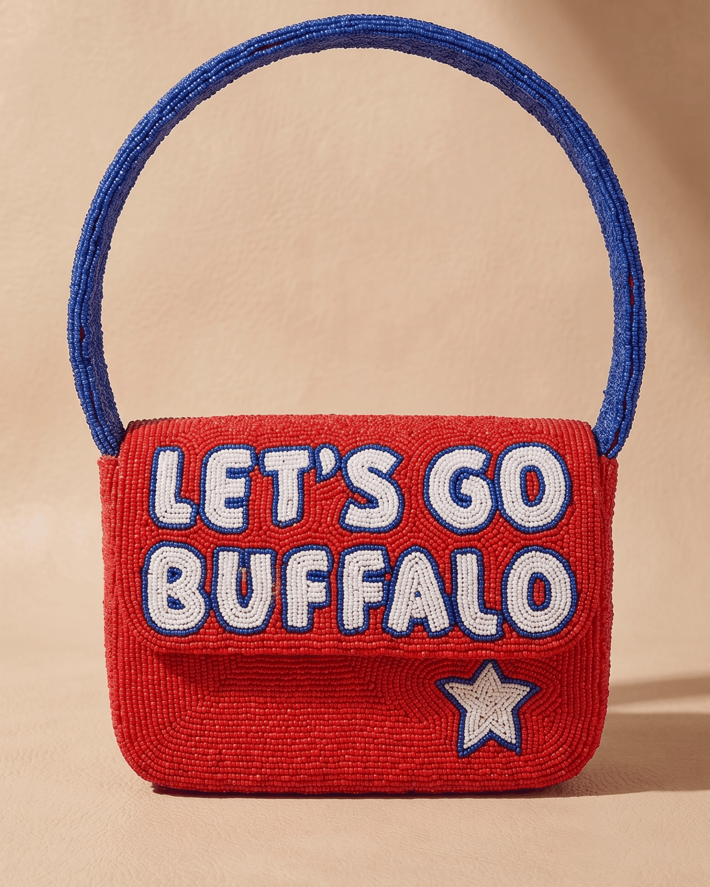 The Rally Buffalo Edition — front of the red hand-beaded bag spelling ‘Let’s Go Buffalo’ in white and blue with a star and blue handle.