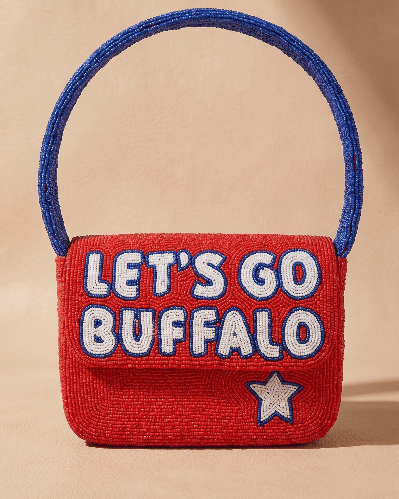 The Rally Buffalo Edition — front of the red hand-beaded bag spelling ‘Let’s Go Buffalo’ in white and blue with a star and blue handle.