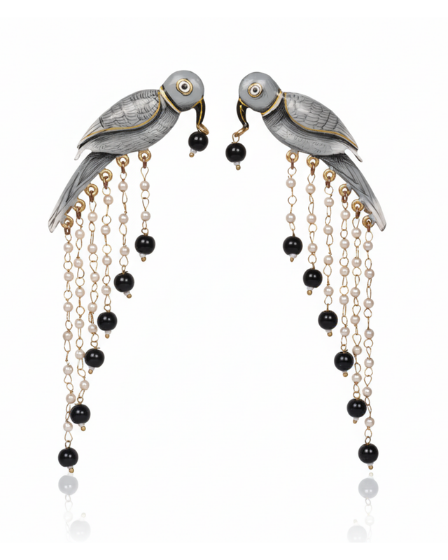 Graphite Parrot Chandelier Earrings carried by a model, styled for evening