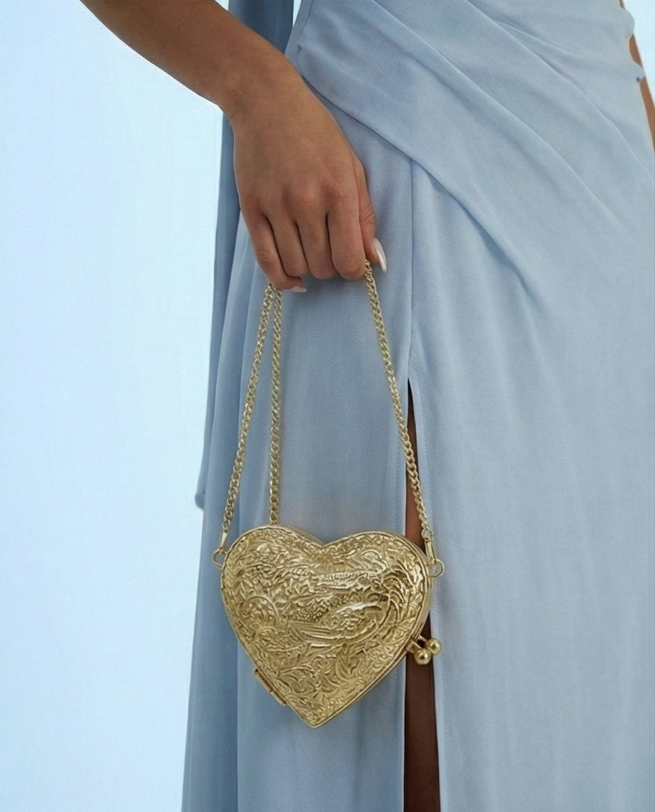 The Amour minaudière held by a model against a neutral outfit