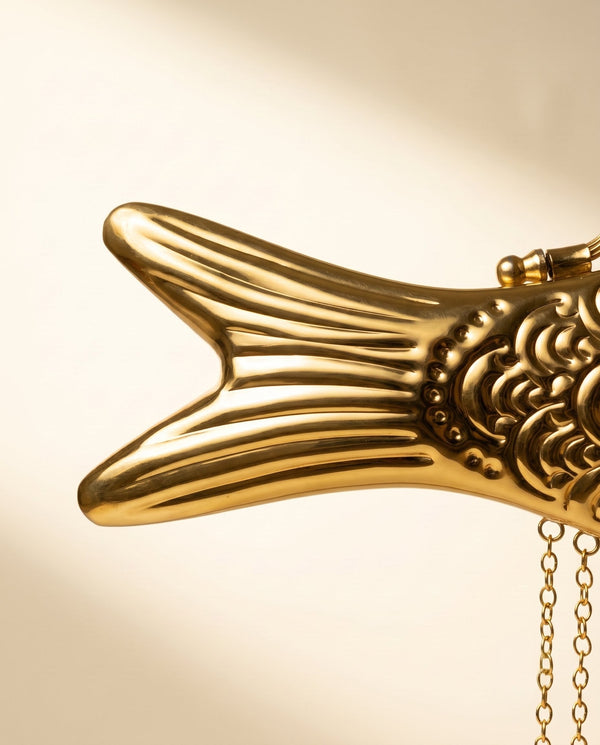 Fluted brass tail of The Monsoon Fish clutch with its beaded seam